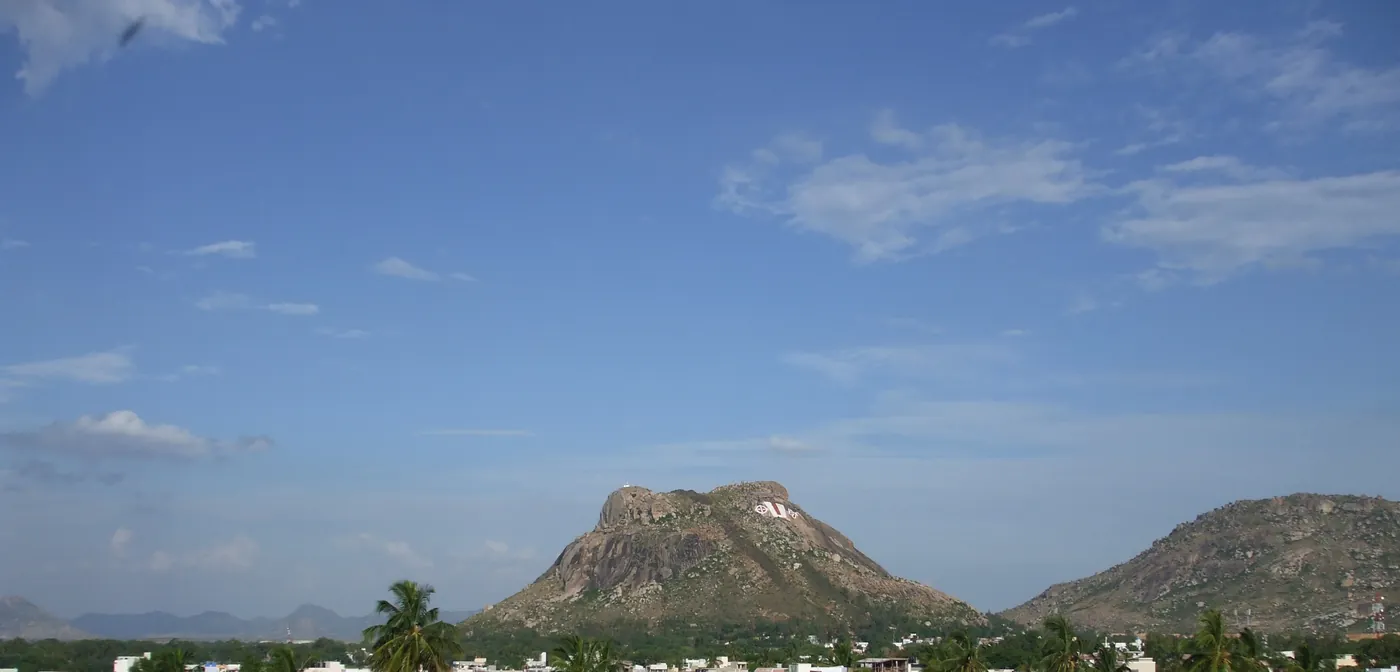 Madanapalle town below its granite hill crowned with a giant white OM emblem